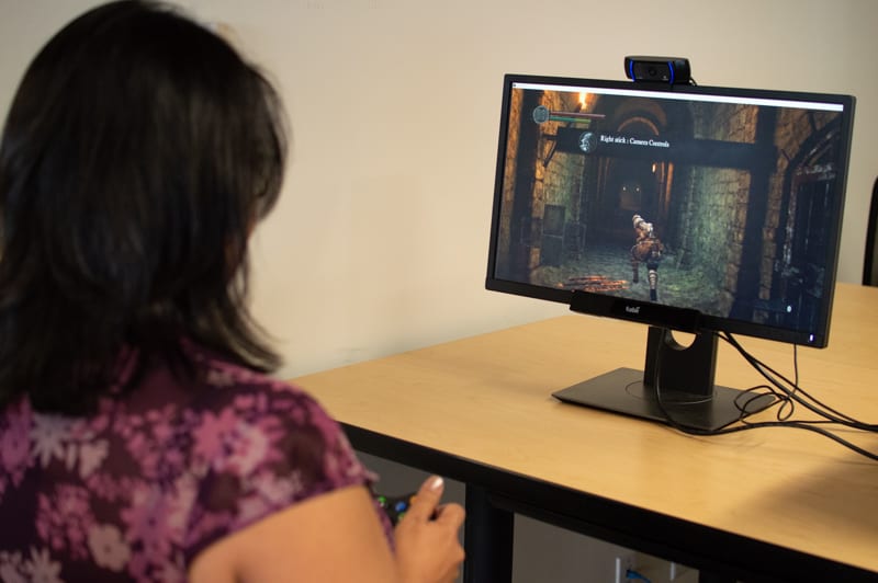 How accurate is Webcam Eye tracking: woman playing a video game in front of a screen with an eye tracking webcam.