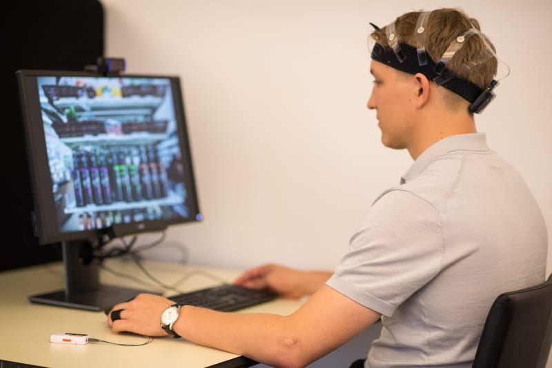 Respondent looking at a screen while his reactions are measured by EEG, GSR and eye tracking