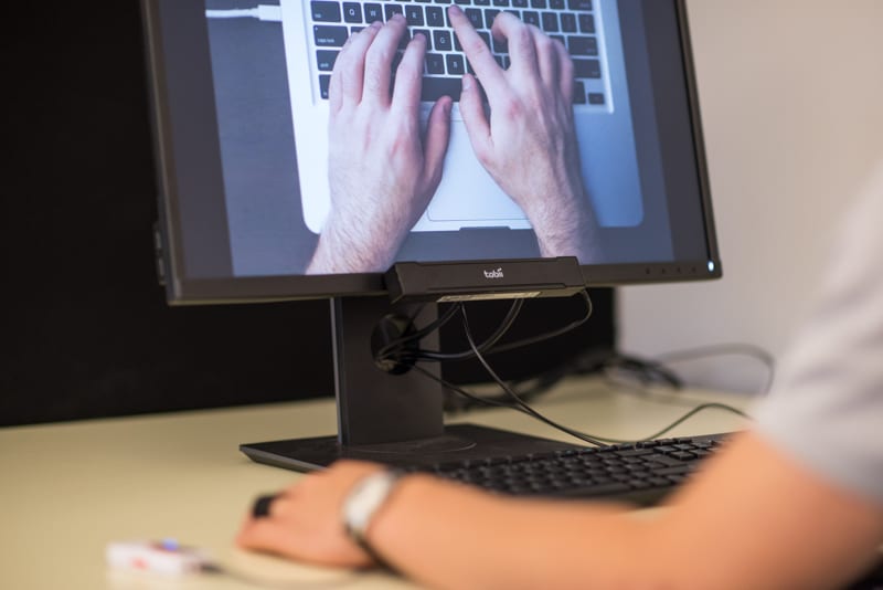 media testing eye tracking man watching a screen displaying two hands writing on a laptop's keyboard