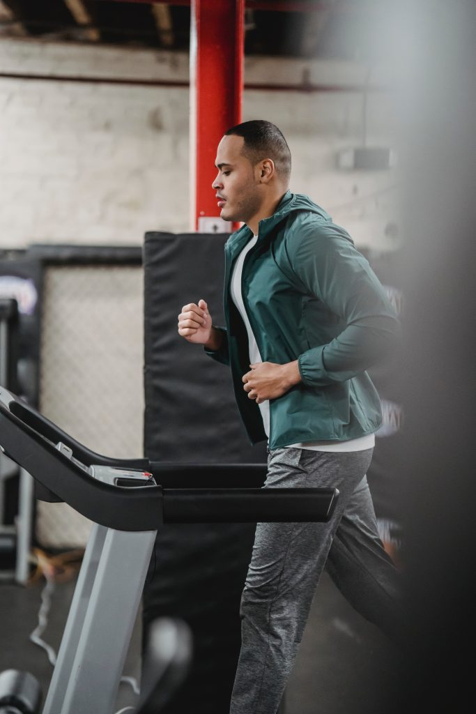 man in workout clothing running on treadmill
